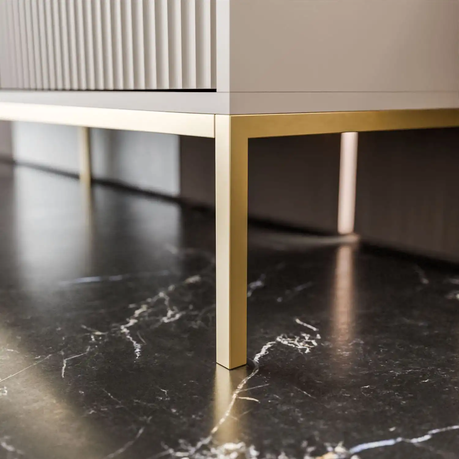 CORTAO naktinis staliukas – elegantiškas ir funkcionalus baldas su grioveliais dekoruotais MDF fasadais, auksinėmis rankenėlėmis ir aukso spalvos plieniniu rėmu.
