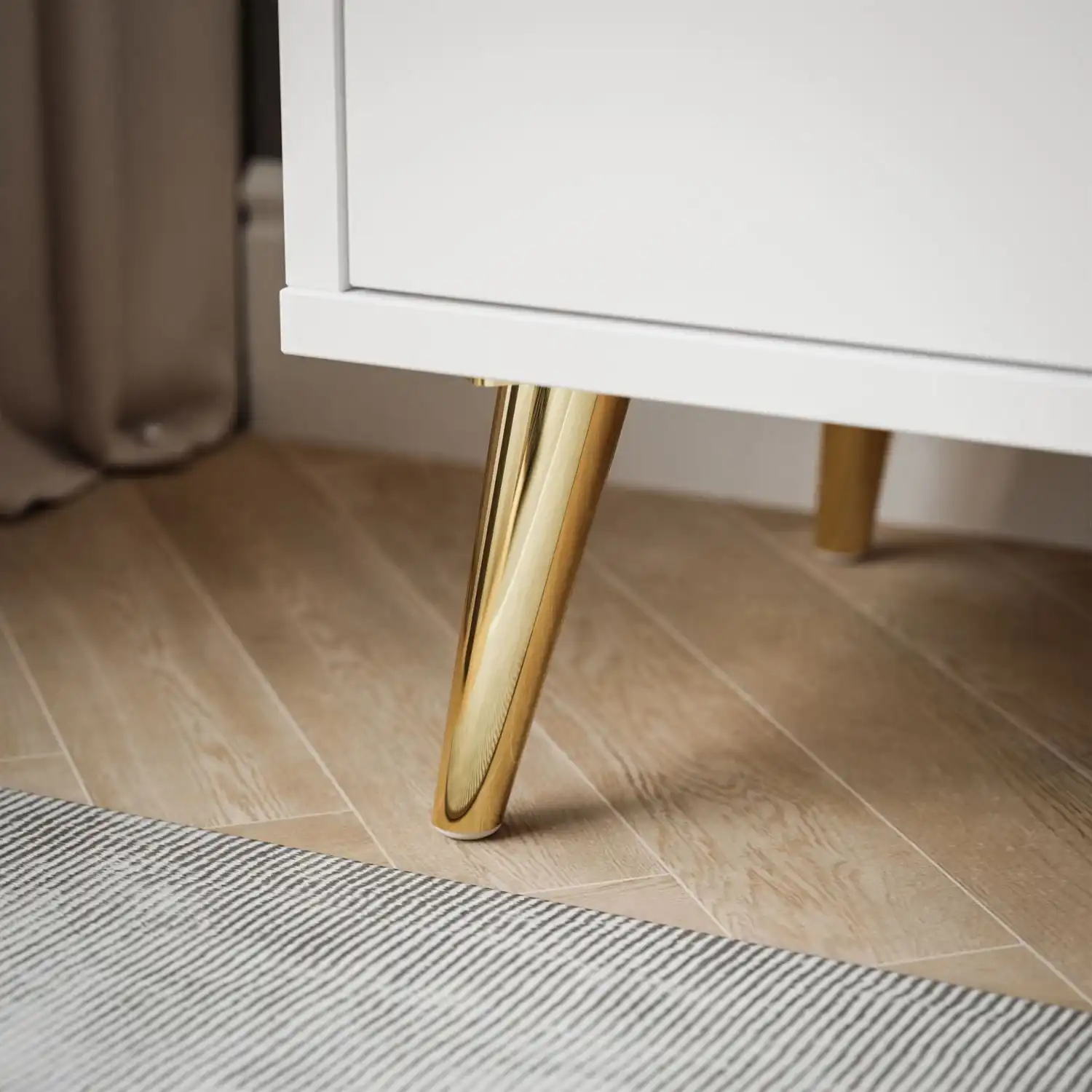 ALDO naktinis staliukas su LED apšvietimu baltas su auksiniais arnamentais Baltas ALDO staliukas su subtiliomis auksinėmis detalėmis ir moderniu dizainu.