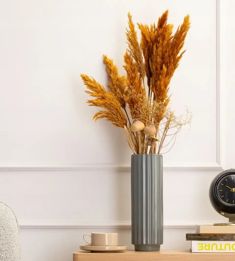 Keraminė vaza su žolių puokšte, galimybė užpilti vandeniu pabrėžia gėlių šviežumą ir dekoratyviai papildo interjerą.