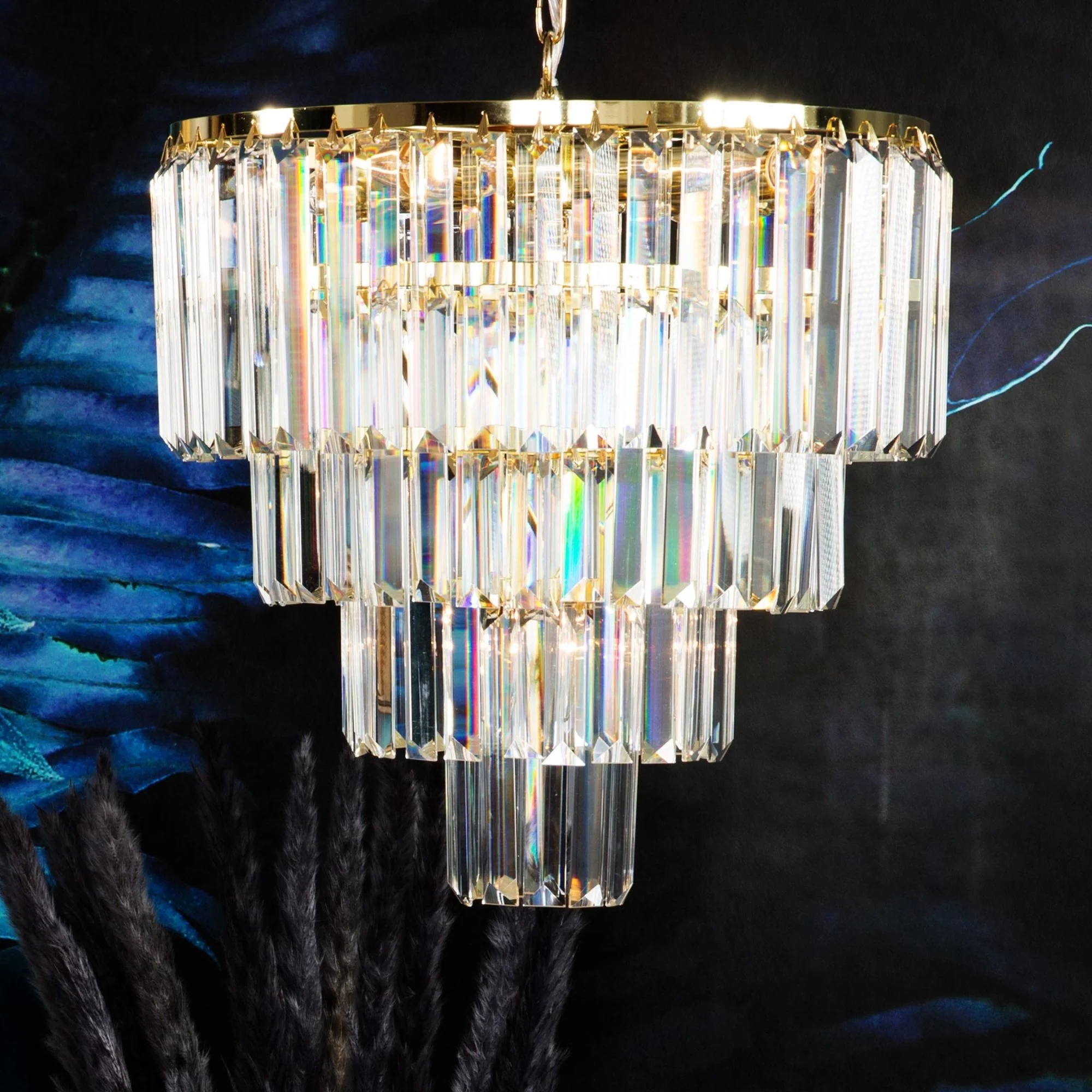 Pakabinamas auksinis šviestuvas AMADEO su keturiais apskritimais iš stiklo kristalų, reguliuojamo aukščio ir E14 lizdu.